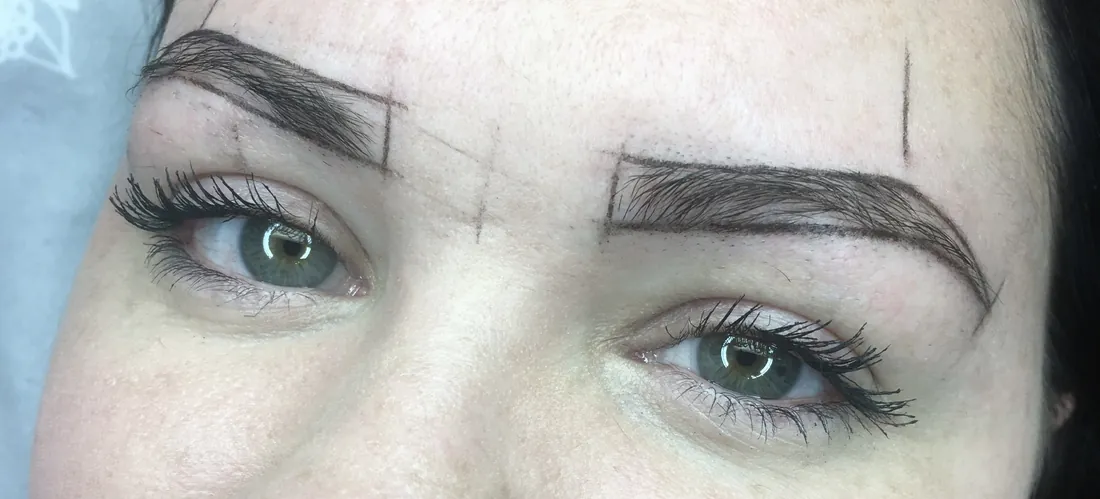 Brow mapping in progress with measured guideline dots and a symmetrical pencil outline drawn around both brows before any pigment is placed